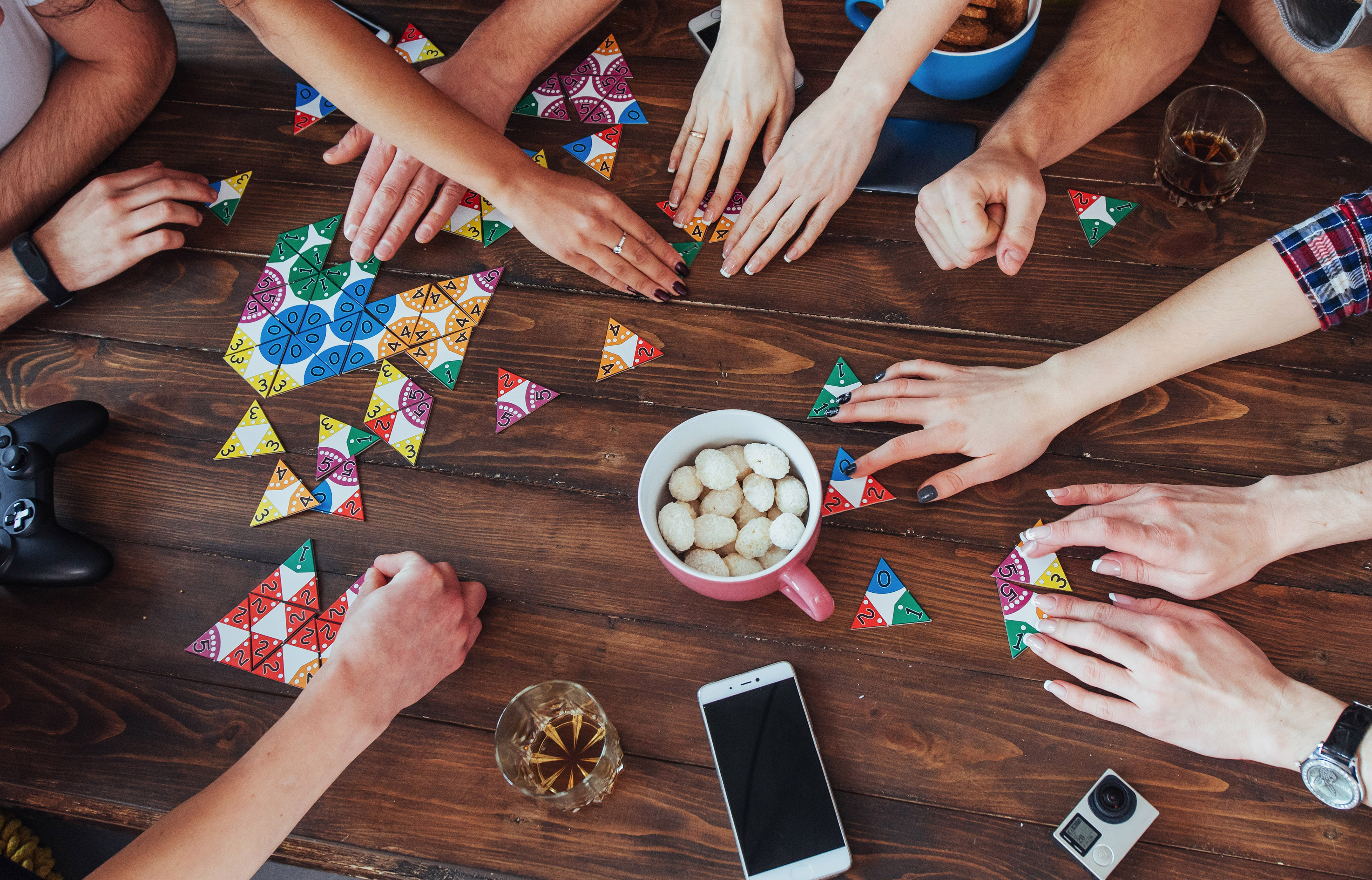 A group of people around a table eating snacks and playing board games